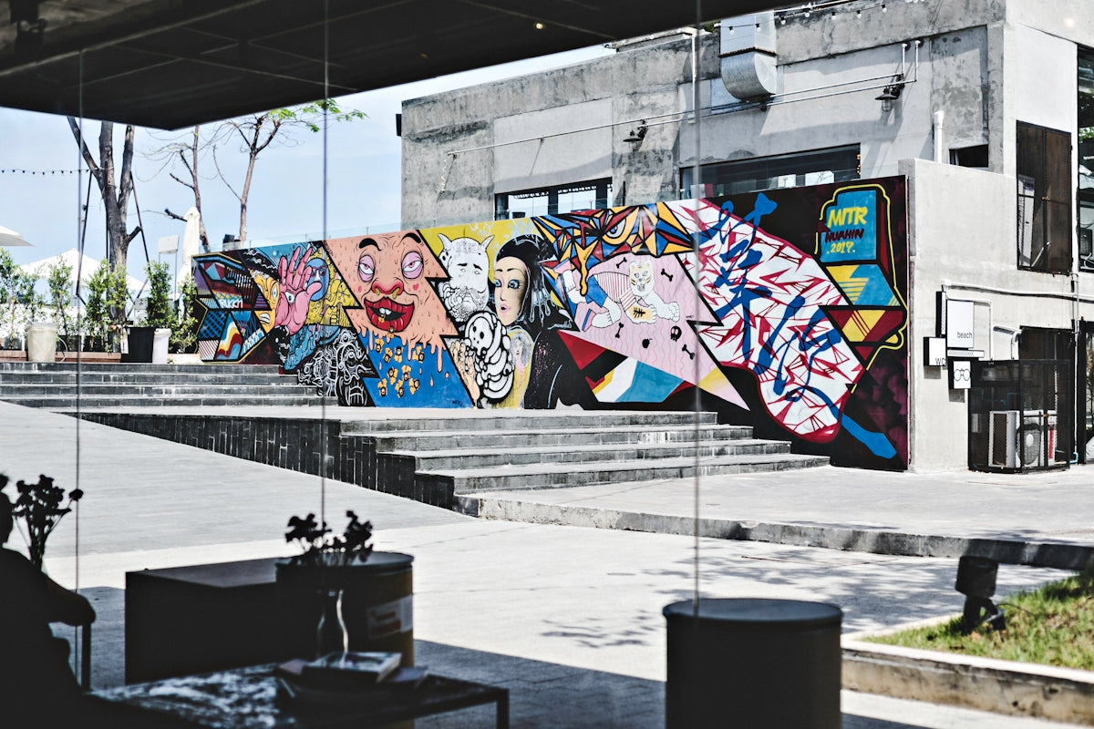 brown and multicolored wall with art at daytime