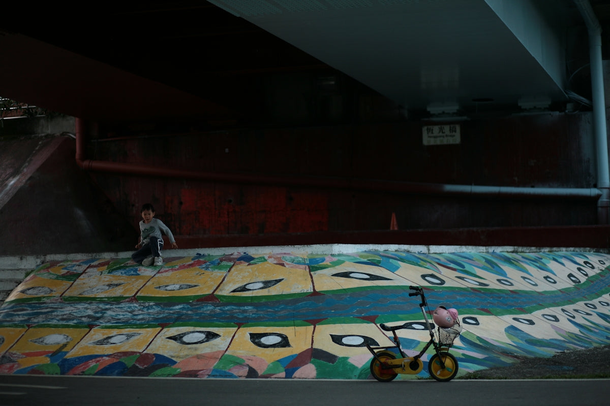 man in white shirt riding bicycle on blue and yellow carpet