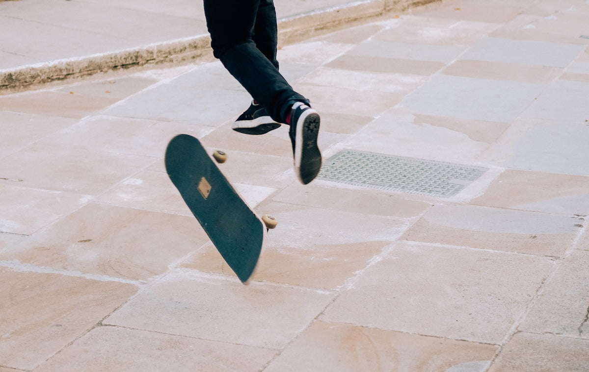 person in black pants and black and white sneakers walking on sidewalk during daytime