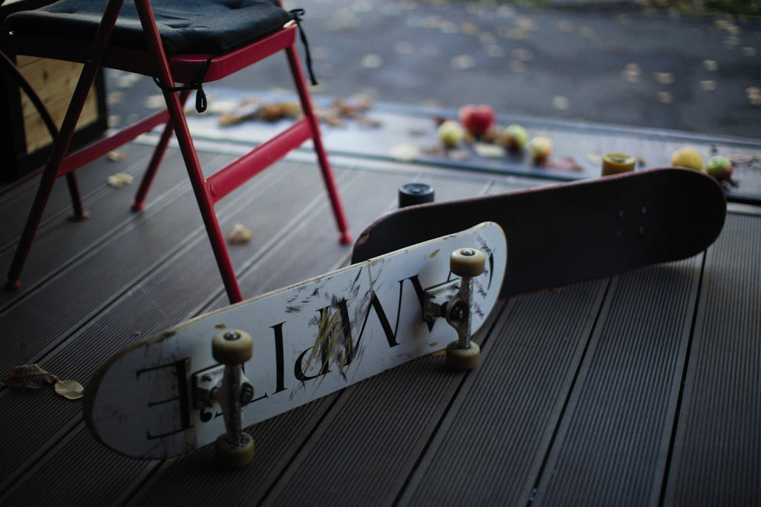 a skateboard laying on the ground next to a chair