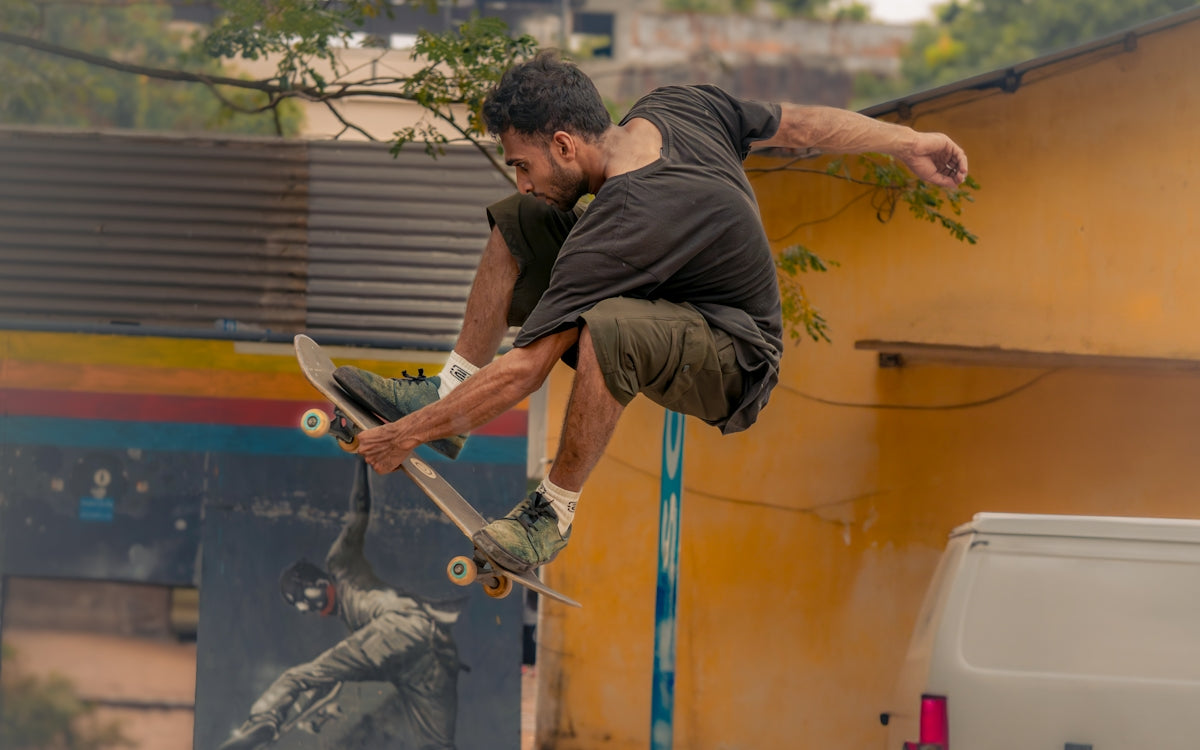 A man on a skateboard does a trick in the air