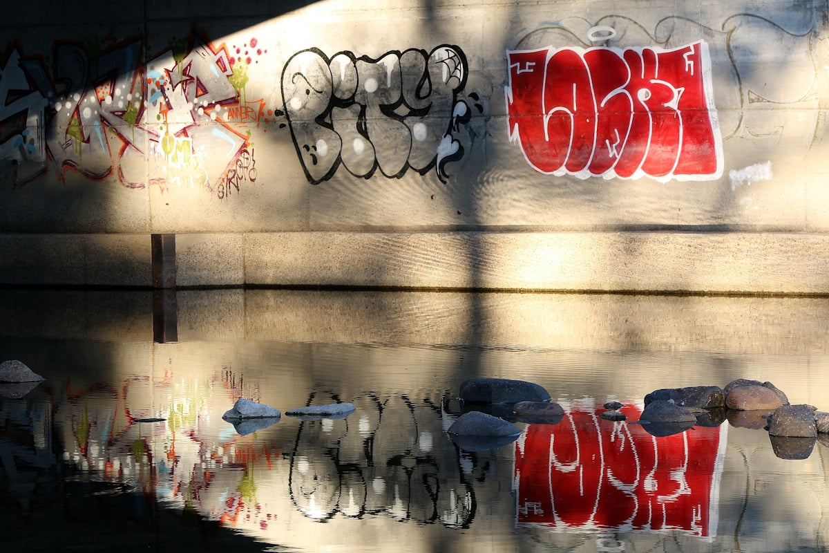 Graffiti on a wall with sunlight and shadows.